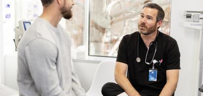 Ein Arzt führt ein Gespräch mit einem Patienten in einer Praxis.