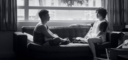 Schwarz-wei&szlig;-Foto: zwei junge M&auml;nner sitzen auf einem Sofa vor einem Fenster